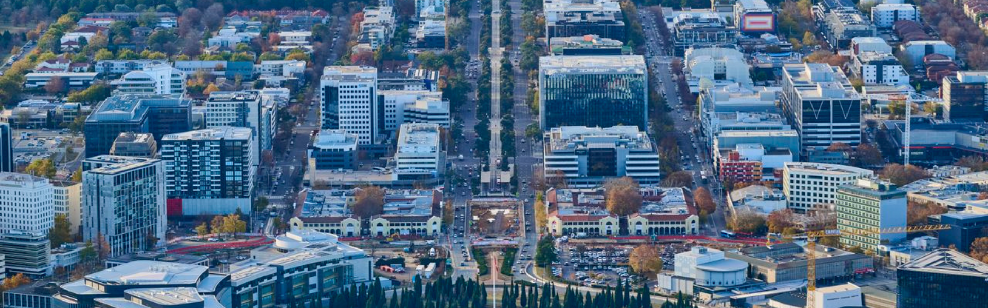 An aerial photo of Canberra’s CBD showing tree lined streets in autumn, apartment living and the built environment in the city. 